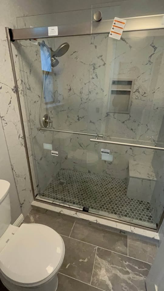 Regadera de azulejo con puerta de vidrio y nicho