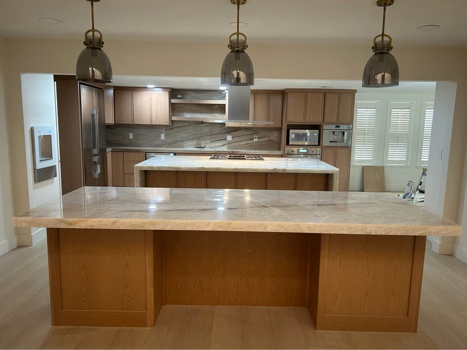 Cocina remodelada con gabinetes de madera e isla de cuarzo